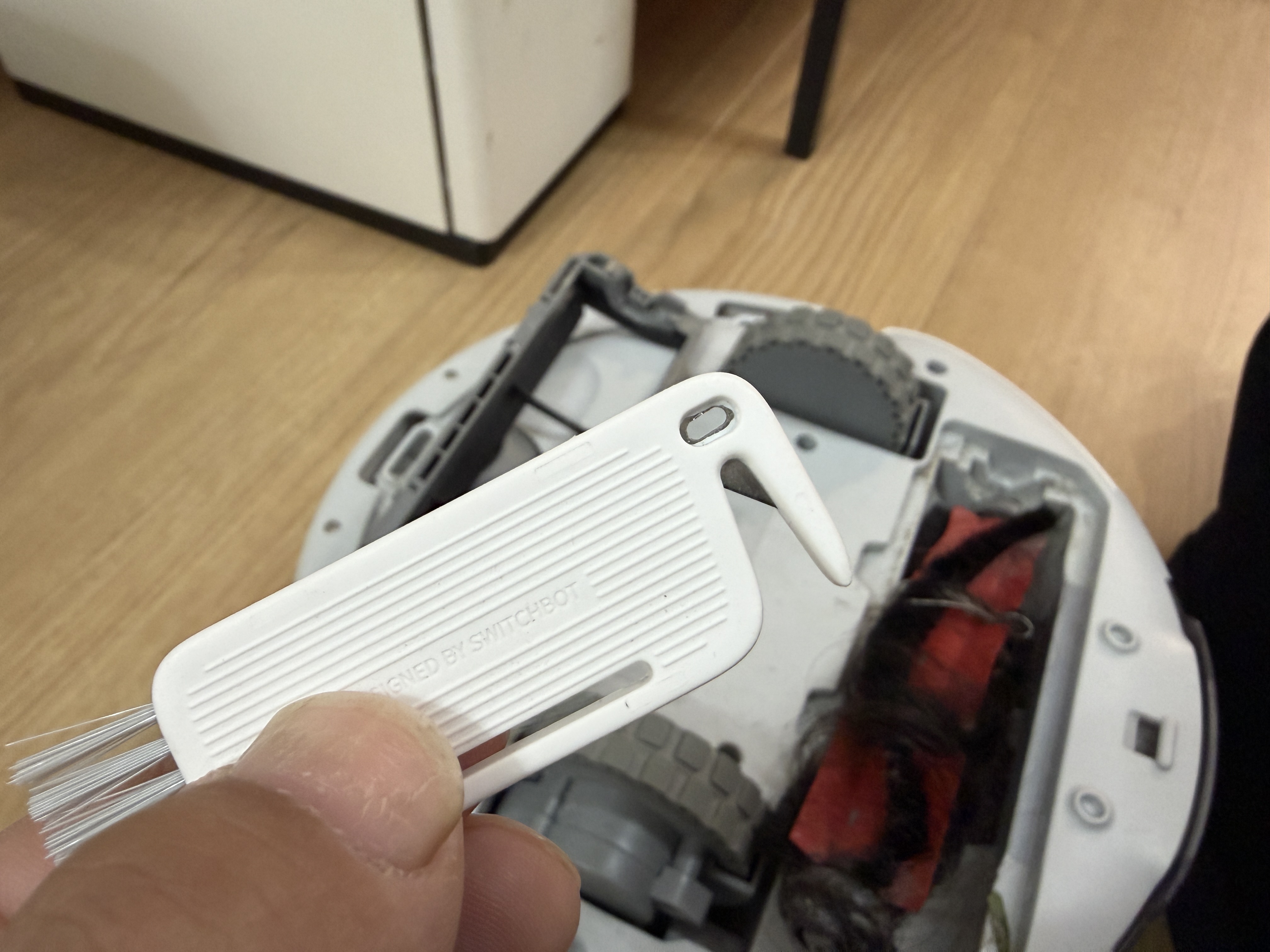 SwitchBot K10+の裏面を付属の清掃ツールでメンテナンスしている様子